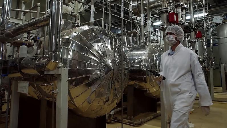 Um oficial de segurança iraniano com vestuário de proteção caminha por uma parte das instalações de conversão de urânio nos arredores da cidade de Isfahan, 30 de março de 2005