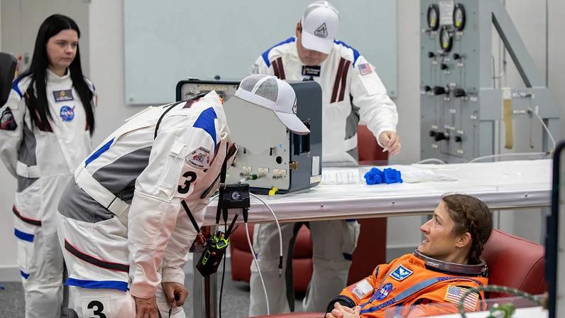Astronauta da ASA Christina Koch, especialista da missão Artemis II, faz verificações ao fato espacial na sala de preparação da tripulação