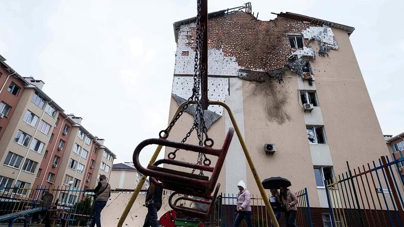 Pessoas caminham em frente a uma casa que ficou danificada após um ataque russo a um bairro residencial em Kriukivshchyna, região de Kiev, Ucrânia, na sexta-feira, 3 de abril de 2026.