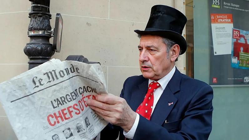 ARQUIVO. Ativista mostra jornal com manchete sobre revelações 'Panama Papers' durante reunião de gestores bancários em Paris, França, abr. 2016