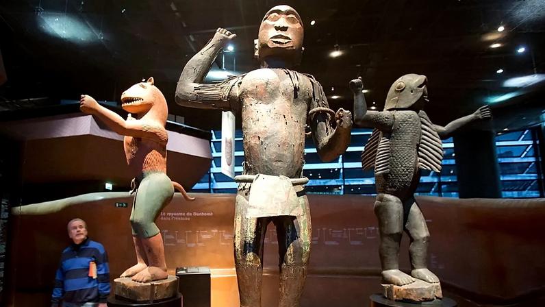 ARQUIVO - Um visitante observa estátuas reais de madeira do reino do Daomé, datadas do século XIX, no museu Quai Branly, em Paris, França, em novembro de 2018.