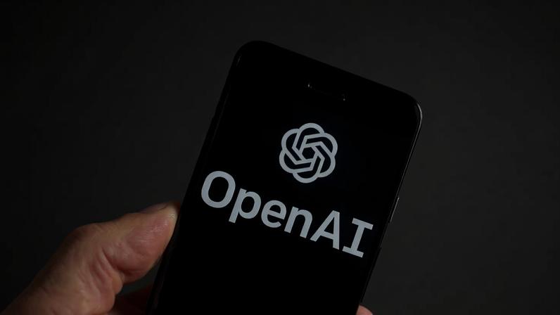 ARQUIVO - Logótipo da OpenAI num telemóvel perante um ecrã com resultados do ChatGPT, 21 de março de 2023, Boston. (Foto AP/Michael Dwyer, Arquivo)