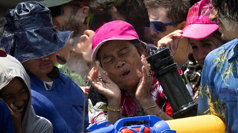 Pessoas participam no festival da água de Songkran para celebrar o Ano Novo tailandês