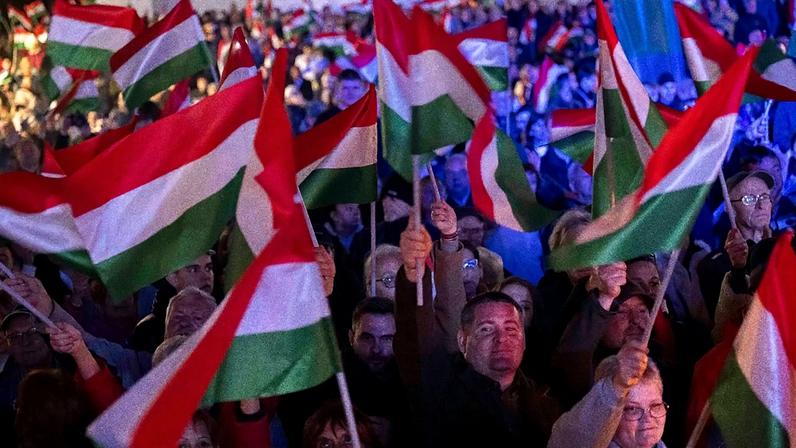 Apoiantes do primeiro-ministro Viktor Orbán agitam bandeiras numa ação de campanha em Kaposvár, Hungria, em 16 de março de 2026, antes das legislativas de 12 de abril.