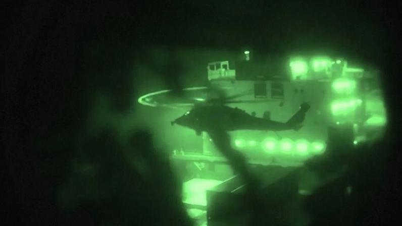 Imagem em visão noturna do Comando Central dos EUA mostra um helicóptero militar e fuzileiros navais a embarcarem num navio no golfo de Omã, em 19 de abril de 2026