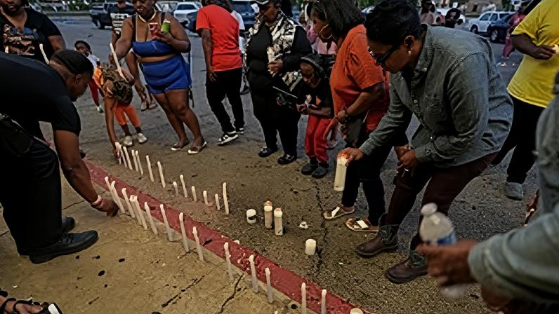 Pessoas acendem velas durante uma vigília de oração pelas vítimas de um tiroteio em massa no início do dia, domingo, 19 de abril de 2026, em Shreveport, Louisiana.