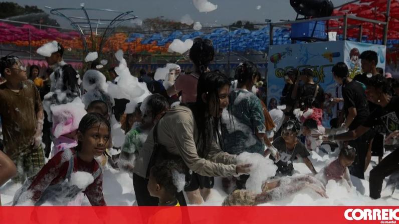 Pessoas divertem-se numa festa com espuma em ambiente aberto