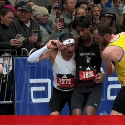 Atleta cai exausto perto da meta na Maratona de Boston e colegas ajudam-no