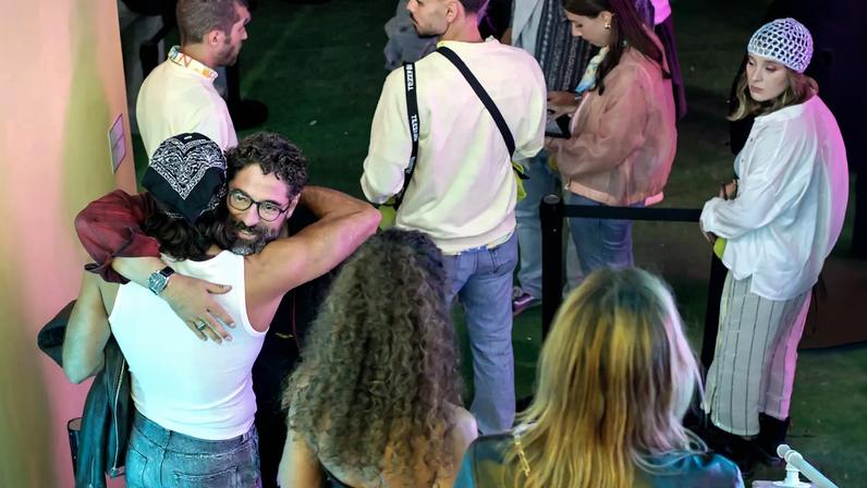 Pessoas reunidas num evento; abraços e sorrisos entre convívio