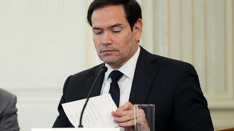 Marco Rubio examina notas durante evento