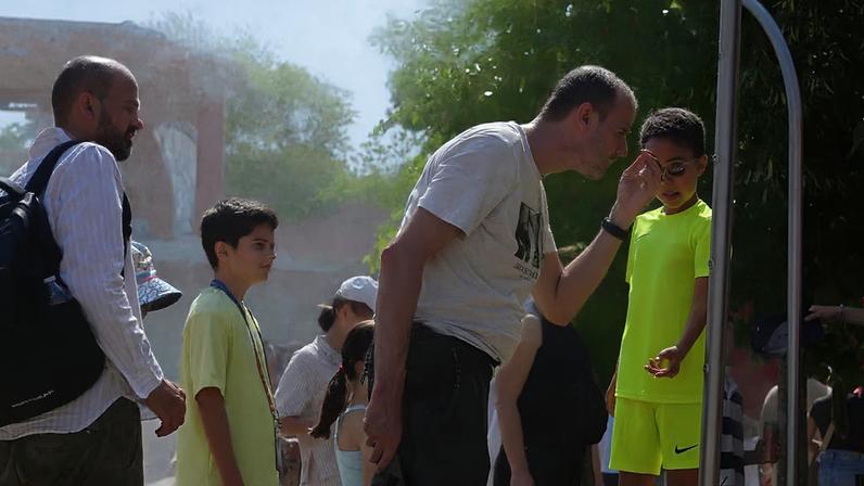 Visitantes refrescam-se com água de aspersores num dia de calor no Open de França de ténis