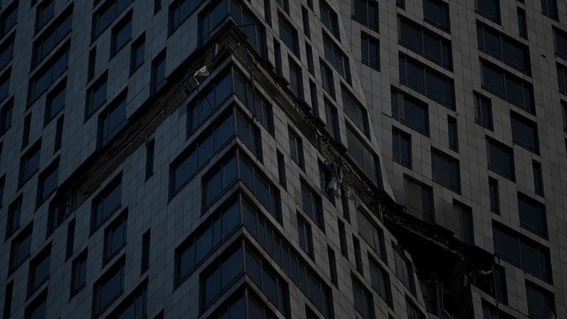 Detritos pendem de um edifício de apartamentos danificado na rua Mosfilmovskaya após um ataque de um drone ucraniano em Moscovo, segunda-feira, 4 de maio de 2026.
