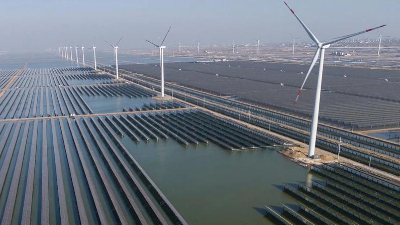Aerogeradores em funcionamento junto a uma central solar perto de Weifang, na província de Shandong, no leste da China, em 22 de março de 2024