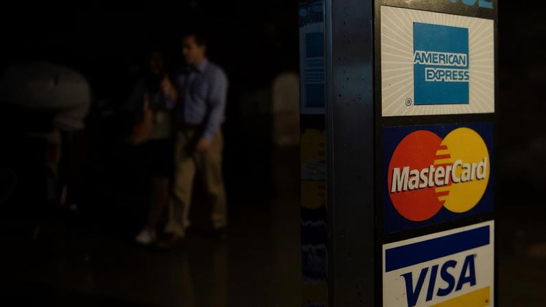 Na foto de arquivo de 23 de julho de 2007, veem‑se autocolantes da American Express, MasterCard e Visa na porta de uma loja em Nova Iorque.