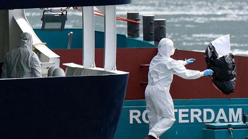 Equipa com proteção retira resíduos do cruzeiro MV Hondius no porto de Roterdão, Países Baixos, em 18 de maio de 2026.