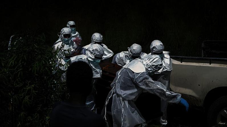 Trabalhadores da Cruz Vermelha preparam um caixão com o corpo de uma vítima de Ébola para sepultura no cemitério de Rwampara, em Bunia, Congo, sábado, 23 de maio de 2026.