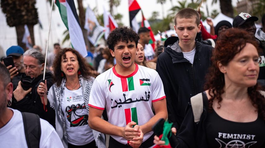 Manifestantes entoam palavras de ordem enquanto se despedem de ativistas que zarpam do porto de Barcelona rumo a Gaza, a 12 de abril de 2026.
