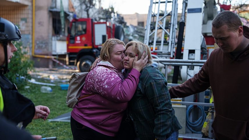 Uma mulher beija o familiar evacuado de uma casa gravemente danificada após um ataque russo a um bairro residencial em Kiev.