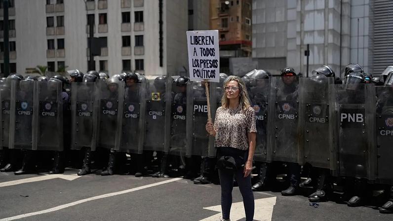 Mulher segura um cartaz numa manifestação que exige justiça para a família de Carmen Navas, um dia após a sua morte em Caracas, Venezuela, segunda-feira, 18 de maio de 2026