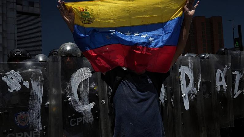 Um homem empunha uma bandeira da Venezuela durante um protesto em Caracas, na Venezuela, segunda-feira, 18 de maio de 2026, pedindo justiça pela morte de Carmen Navas.