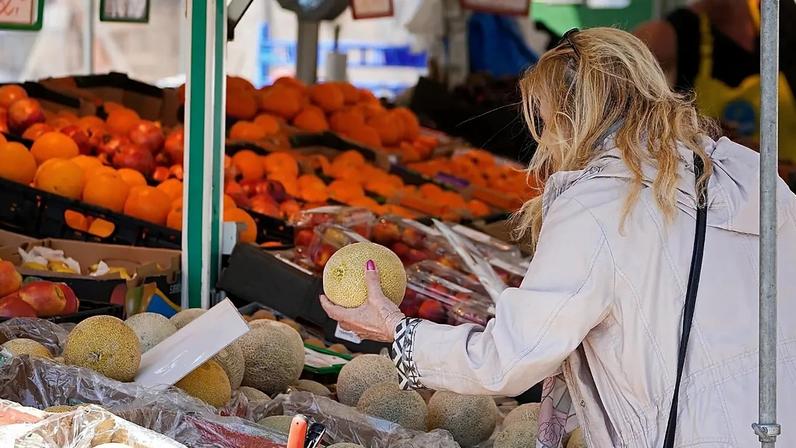 Uma mulher verifica o preço de uma melancia em Essen, numa altura de elevada inflação alimentar na Alemanha, em maio de 2023