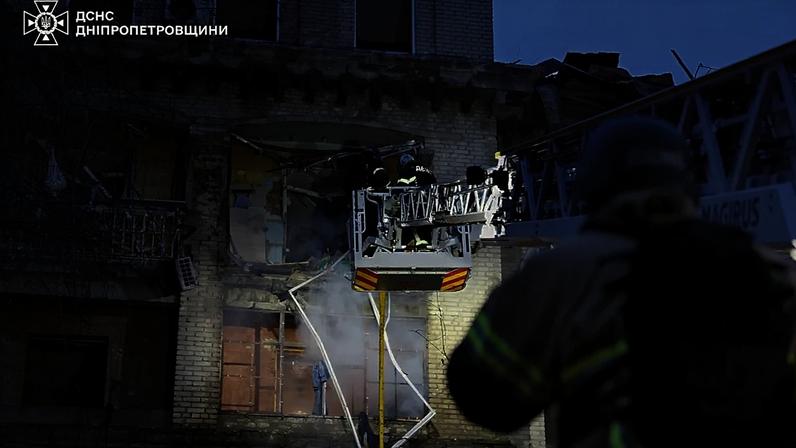 Equipas de salvamento apagam um incêndio num edifício residencial danificado após uma greve russa em Dnipro, 18 de maio de 2026
