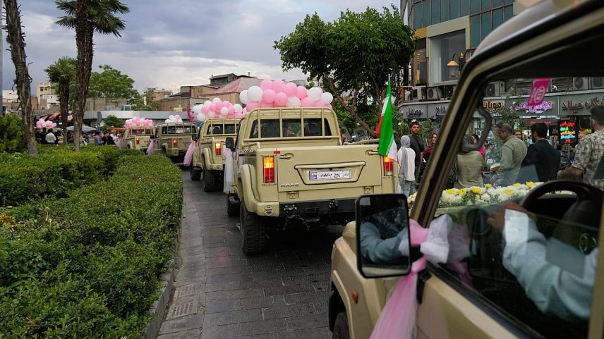 Casais recém-casados seguem em carrinhas de caixa aberta durante um casamento coletivo da campanha «Janfada», em Teerão, Irão, segunda-feira, 18 de maio de 2026.