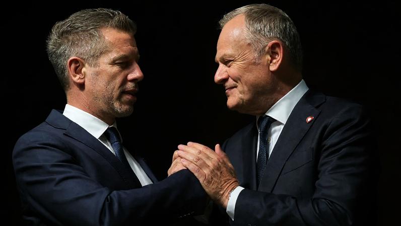 Primeiro-ministro polaco Donald Tusk, à direita, e primeiro-ministro húngaro Peter Magyar apertam as mãos após conferência de imprensa em Varsóvia, Polónia, 20 de maio de 2026