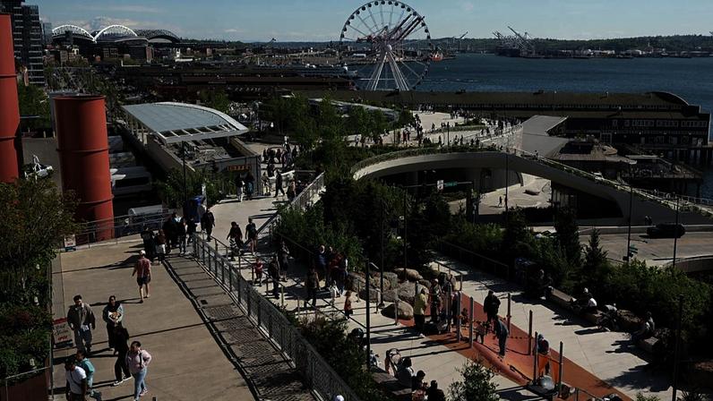 Visitantes passeiam na Overlook Walk, que liga o mercado de Pike Place à zona ribeirinha de Seattle, na baía Elliott