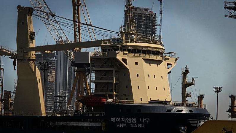 Ficheiro: navio sul-coreano HMM NAMU atracado após danos de incêndio no estreito de Ormuz, num porto de Dubai, Emirados Árabes Unidos, 8 maio 2026