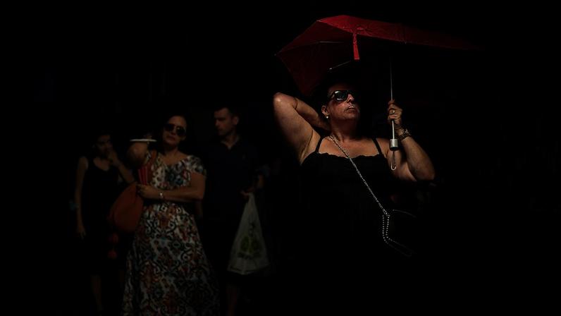 ARQUIVO - Uma mulher segura um guarda-chuva para se proteger do sol durante um dia quente e soalheiro em Madrid, Espanha, segunda-feira, 18 de julho de 2022.