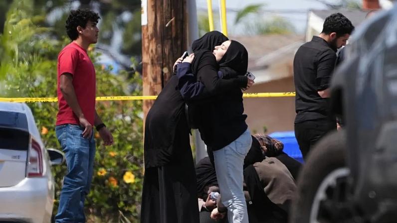 Pessoas abraçam-se perto do local de um tiroteio no exterior do Centro Islâmico de San Diego, segunda-feira, 18 de maio de 2026, em San Diego