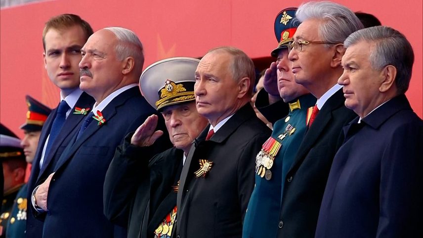 Presidente russo Vladimir Putin observa com outros líderes e responsáveis, incluindo o presidente bielorrusso Aleksandr Lukashenko
