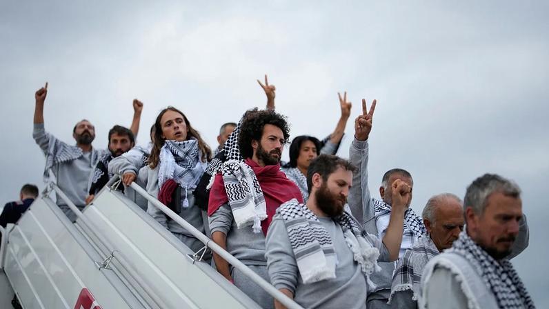 Ativistas da flotilha Global Sumud desembarcam de um avião à chegada ao aeroporto de Istambul