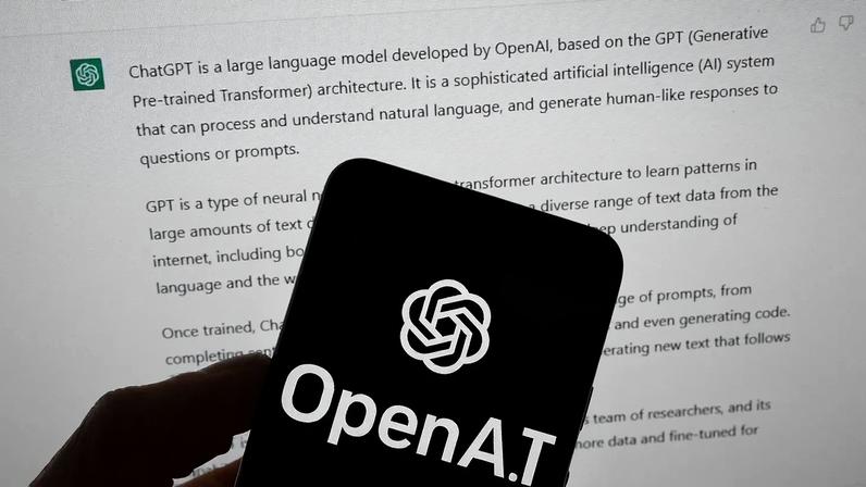 O logótipo da OpenAI é visto num telemóvel em frente a um ecrã de computador que apresenta resultados do ChatGPT, a 21 de março de 2023, em Boston.