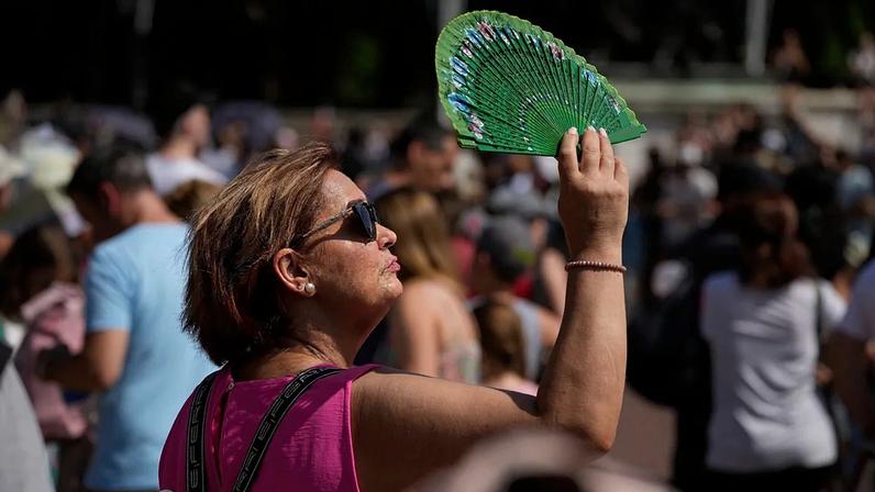 ARQUIVO – Uma mulher usa um leque para proteger o rosto do sol em Londres durante a onda de calor de 18 de julho de 2022.