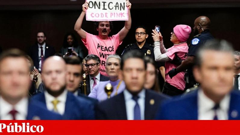 Um opositor à guerra no Irão com um cartaz na audição do secretário da Defesa, Pete Hegseth, no Senado, na quinta-feira