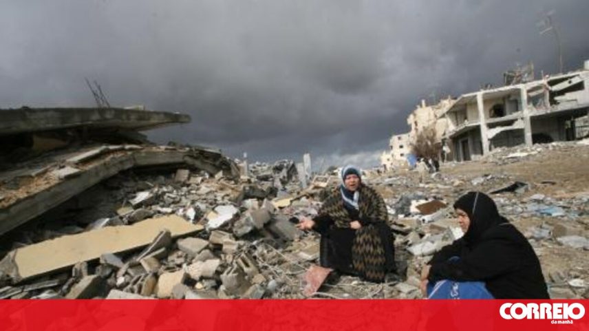 Mulheres em Gaza entre destroços, após ofensiva de Israel que vitimou milhares