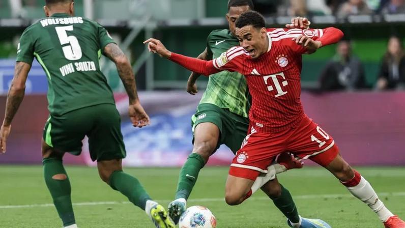 Disputa de bola acesa entre jogadores do Bayern e Wolfsburg na Bundesliga
