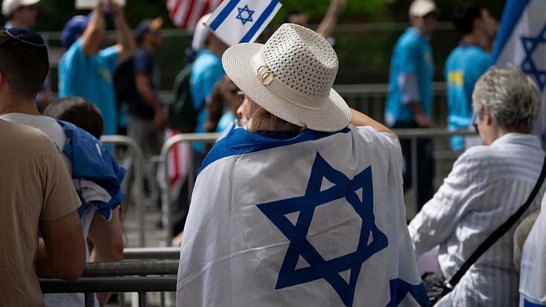 Uma mulher agita uma bandeira de Israel durante o desfile do Dia de Israel, domingo, 31 de maio de 2026, em Nova Iorque.
