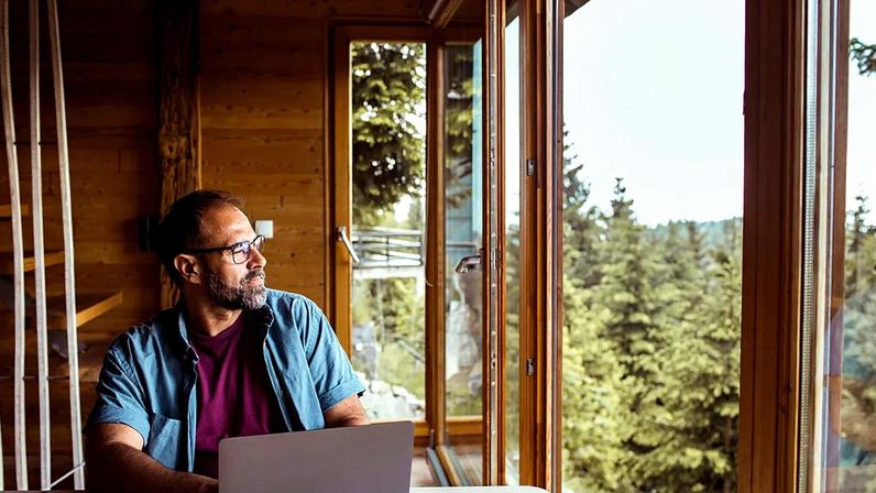 Foto ilustrativa de homem a trabalhar a partir de casa