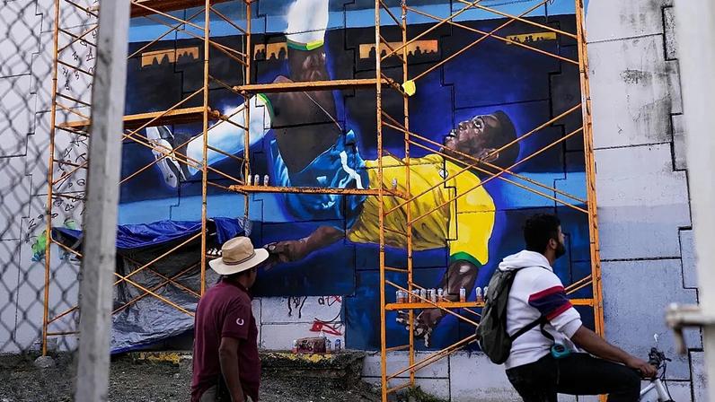 Pessoas passam diante de um mural com o lendário futebolista brasileiro Pelé, antes da inauguração do Mundial da FIFA, em Guadalajara, México, 10 de junho de 2026
