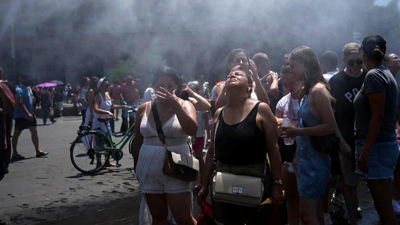 Pessoas refrescam-se junto a um canhão de água trazido pelo município de Roma Pessoas refrescam-se junto a um canhão de água trazido pelo município de Roma