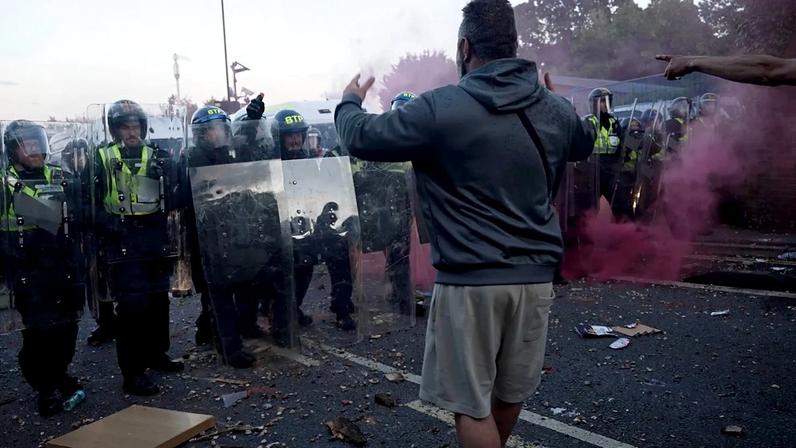 Nesta imagem retirada da PA Video, polícia e manifestantes confrontam-se durante um protesto após a morte de Henry Nowak, um estudante de 18 anos esfaqueado com um kirpan sikh