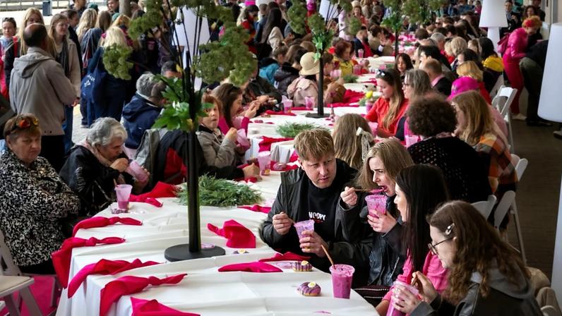 Pessoas comem sopa rosa numa pausa cor‑de‑rosa do Pink Soup Fest, na plataforma da estação ferroviária de Vilnius, Lituânia, sexta‑feira, 29 de maio de 2026
