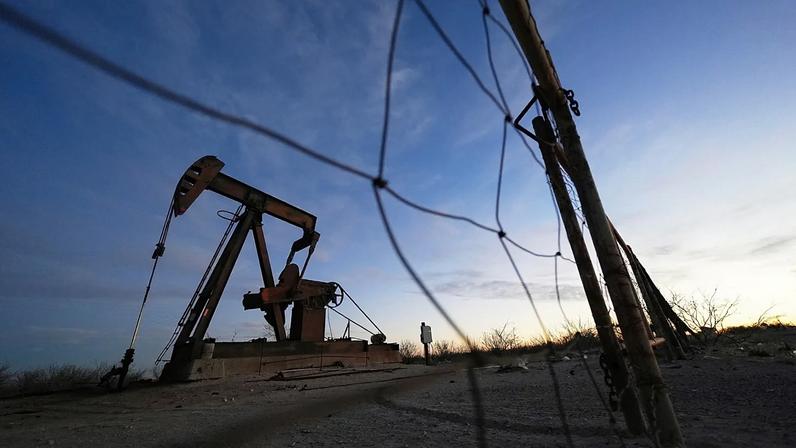 Uma bomba extratora de petróleo é visível antes do nascer do sol, a 26 de fevereiro de 2025, em Kermit, no Texas.