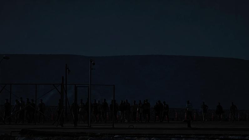 ARQUIVO - Migrantes resgatados a sul de Creta caminham após chegarem ao porto de Lavrio, Grécia, em 10 de julho de 2025