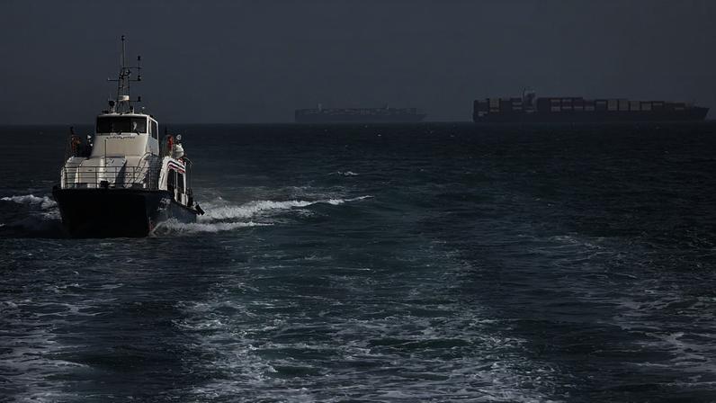 ARQUIVO: Lancha de patrulha navega entre navios de carga fundeados no estreito de Ormuz, ao largo de Bandar Abbas, em 2 de maio de 2026