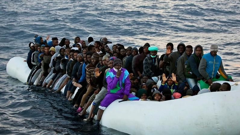 Migrantes e refugiados aguardam ajuda de membros da ONG espanhola Proactiva Open Arms, apinhados a bordo de um barco insuflável à deriva no mar Mediterrâneo