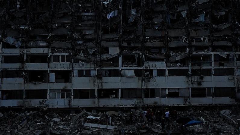Equipas de resgate procuram entre os escombros de um edifício que ruiu quando sismos atingiram La Guaira, em 28 de junho de 2026
